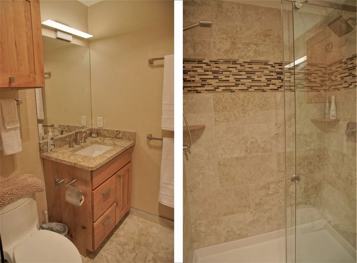 A spa-like ensuite bathroom with a granite countertop, glass shower door, wood cabinetry, and stylish tile accents. The atmosphere is tranquil and inviting, ideal for post-adventure relaxation and self-care.